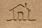 House(home) icon or sign drawing in beach sand - concept photo