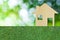 House icon from wooden on grass texture nature background as symbol of mortgage