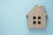 House insurance and mortgage, buying or rent concept. Wooden model house over blue background, top view with copy space