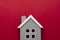 House insurance and mortgage, buying or rent concept.Wooden model house over red background, top view with copy space