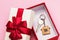 House key in a box on a pink background. Real estate gift concept