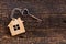 House key in heart shape with home keyring on old wood background