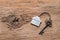 House key with home keyring decorated with mini heart on rusty wood background