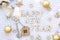 House key with keychain cottage on festive knitted background with stars, lights of garlands. Happy New Year wooden letters,