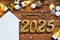 House key with tiny figure of home mock up on festive brown wooden background, lights of garlands. New Year 2025 wooden letters,