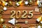 House key with tiny figure of home mock up on festive brown wooden background, lights of garlands. New Year 2025 wooden letters,