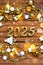 House key with tiny figure of home mock up on festive brown wooden background, lights of garlands. New Year 2025 wooden letters,