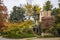 House that looks like an Italian villa with balconies and red tile roof with lush autum foliage turning colors on overcast day - s