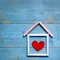 House made of chalk with red heart in it on blue wooden background. Sweet home concept. Mortgage