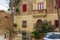 House in Mdina with red door and windows` shutters, and with lush Nerium oleander bush