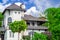 House Mediterranean style, green trees and lilac bushes in front