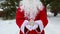 House, miniature cottage in hands of Santa Claus outdoor in snow. Deal for real estate, purchase, construction, relocation, mortga