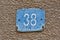 House name plate number 38 written in white on a blue background