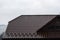 House with new brown metal tile roof and rain gutter. Metallic Guttering System, Guttering and Drainage Pipe Exterior