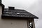 House with new brown metal tile roof and rain gutter. Metallic Guttering System, Guttering and Drainage Pipe Exterior