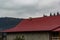 House with new brown metal tile roof and rain gutter. Metallic Guttering System, Guttering and Drainage Pipe Exterior