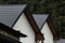 House with new brown metal tile roof and rain gutter. Metallic Guttering System, Guttering and Drainage Pipe Exterior