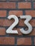 House number 23, white numbers on a clinker wall