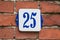 House Number 25 blue and white on traditional wall