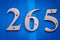 House number 265 in bold, large steel metal digits on a blue wooden front door