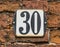 House Number 30 on traditional dutch brick wall