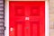 House number 32 on a bright red wooden front door