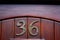 House number 36 on a curved carved varnished door