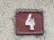House number 4 on a grunge brown plate