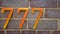 House number seven hundred and seventy seven 777 on brick wall background