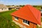 House with an orange  of metal, top view. Metallic profile painted corrugated on the roof