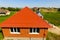 House with an orange  of metal, top view. Metallic profile painted corrugated on the roof