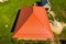 House with an orange of metal, top view. Metallic profile painted corrugated on the roof