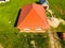 House with an orange roof of metal, top view. Metallic profile painted corrugated on the roof