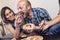 House party. Friends eating and having fun. Man playfully takes a slice of pizza at the woman