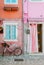 House with pink wall and bike. Colorful houses in Burano island near Venice, Italy