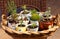 House plants and succulents potted in old cups, jug and tea pot on wicker tray in garden, retro alternative to plastic pots