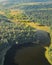 House on plot on the shore of a large lake among green forests with trees - aerial drone shot