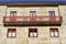 House with red iron handrail, stone walls and red wood windows. Pontevedra, Galicia, Spain. Sunny day, blue sky.