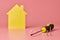 House renovation concept. Home repair and redecorated. Screws and yellow house shaped figure on pink background