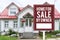 A House For Sale by owner or FSBO sign in front of a large 2 story house. A residence sold directly by the owner and without an