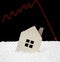 House sinking into polystyrene particle with a downward arrow on background