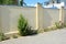 House stone fence with stucco, roses bush and juniper tree