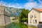 House with tile roof, canal and fortress wall in the city of Kotor, in Montenegro