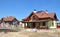 House under construction. House construction site with clay roof, lightning rod, solar water heater panels, attic skylight windows