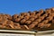 A house under construction with stacks of tile shingles on the roof.