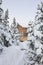 House under snow in winter wood chalet among spruce trees in the