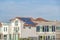 House with white exterior wall and solar panels on tile roof in Huntington Beach