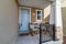 House with white front door and rocking chairs at the small porch with railing