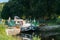 Houseboats with tourists pass through river locks on the river Oust near Josselin in Brittany