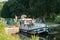 Houseboats with tourists pass through river locks on the river Oust near Josselin in Brittany